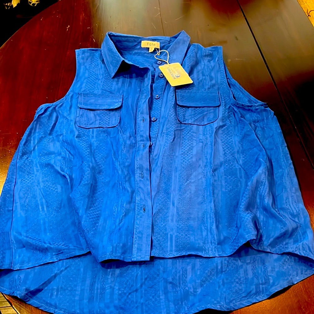Royal blue sleeveless top. Button for two pockets with detail within fabric